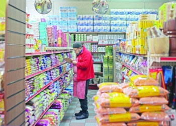 A worker checks the stock inside Taj Stores in east London on March 31, 2023. - Ramadan, which is the Islamic holy month celebrated globally and by the nearly 4 million Muslims in England and Wales, is affected by inflation in the UK hovering above 10%. Prices of food and drink in particular are rising rapidly with British stores seeing the highest grocery inflation in 18 years as of March, according to the UK�s leading retailer trade association the British Retail Consortium. Taj Stores owner has had to increase prices as well. �This makes it a bit more difficult for people already suffering from high costs of living,� said Jamal Khalique, 51, co-owner of the family-run business which sells everything from fresh produce and halal meat to delectable sweets and snacks imported from South Asia. (Photo by Susannah Ireland / AFP)