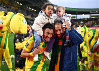 Nantes' Egyptian forward Mostafa Mohamed #31 (L) and British midfielder Sorba Thomas #22 (C) celebrate their victory with kids after the French L1 football match between FC Nantes and Lille LOSC at the Stade de la BeaujoireLouis Fonteneau in Nantes, western France, on March 15, 2025. (Photo by Sebastien Salom-Gomis / AFP)