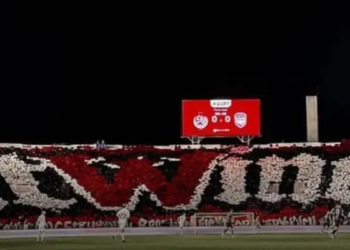 جماهير في مدرجات ملعب خلال مباراة ليلية